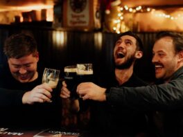 Three men cheers pints at PJ O'Brien's Southgate