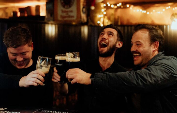 Three men cheers pints at PJ O'Brien's Southgate